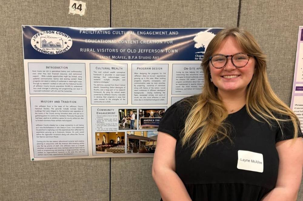 Layne McAfee posing in front of poster presentation