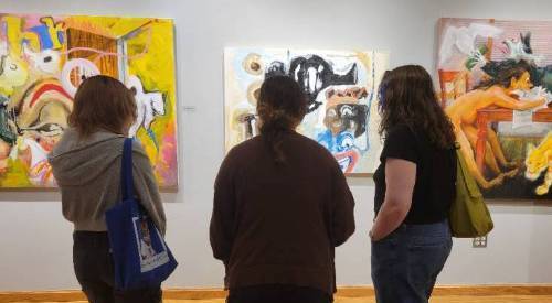 People viewing work in the gallery for the 2025 MFA Exhibit